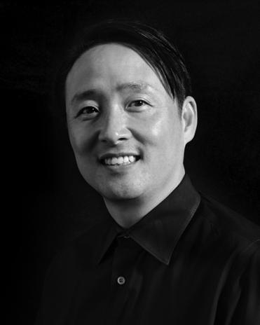 A man in black shirt smiling for the camera.